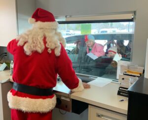 Santa at drive up with children.